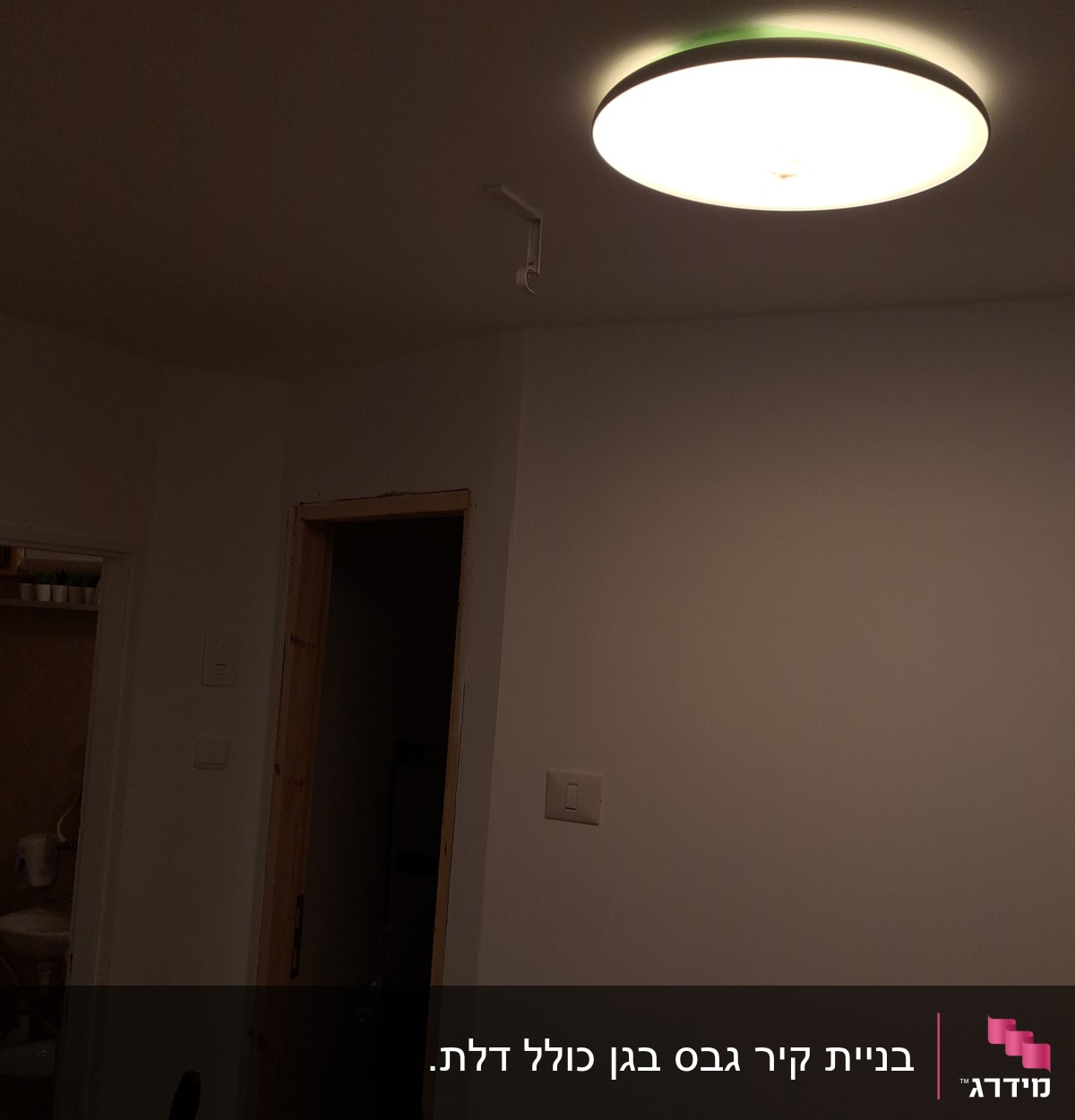 קיר גבס עם מתג תאורה ודלת עץ